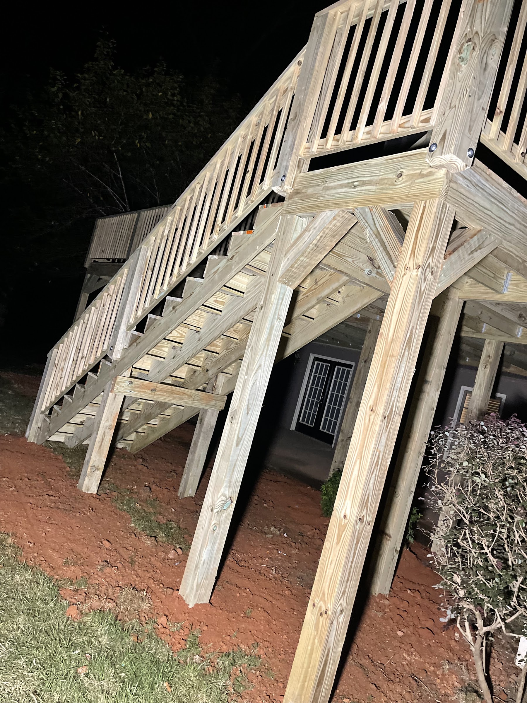 Structural underside of a newly-built deck with sawn lumber bracing