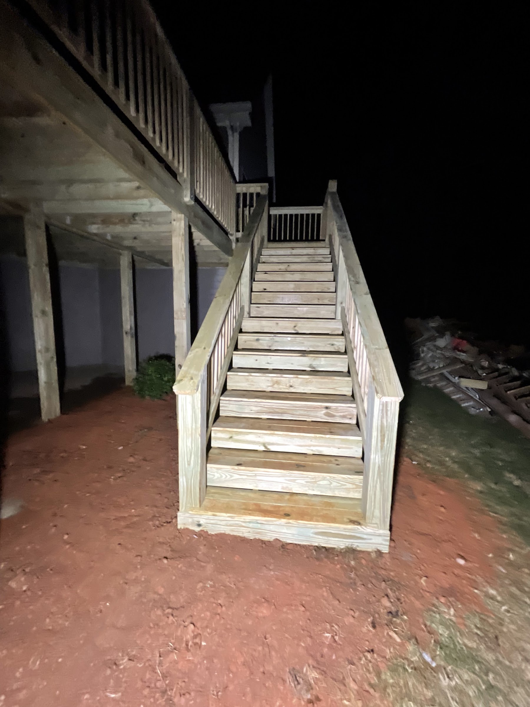 Newly built wood staircase leading up to a back deck