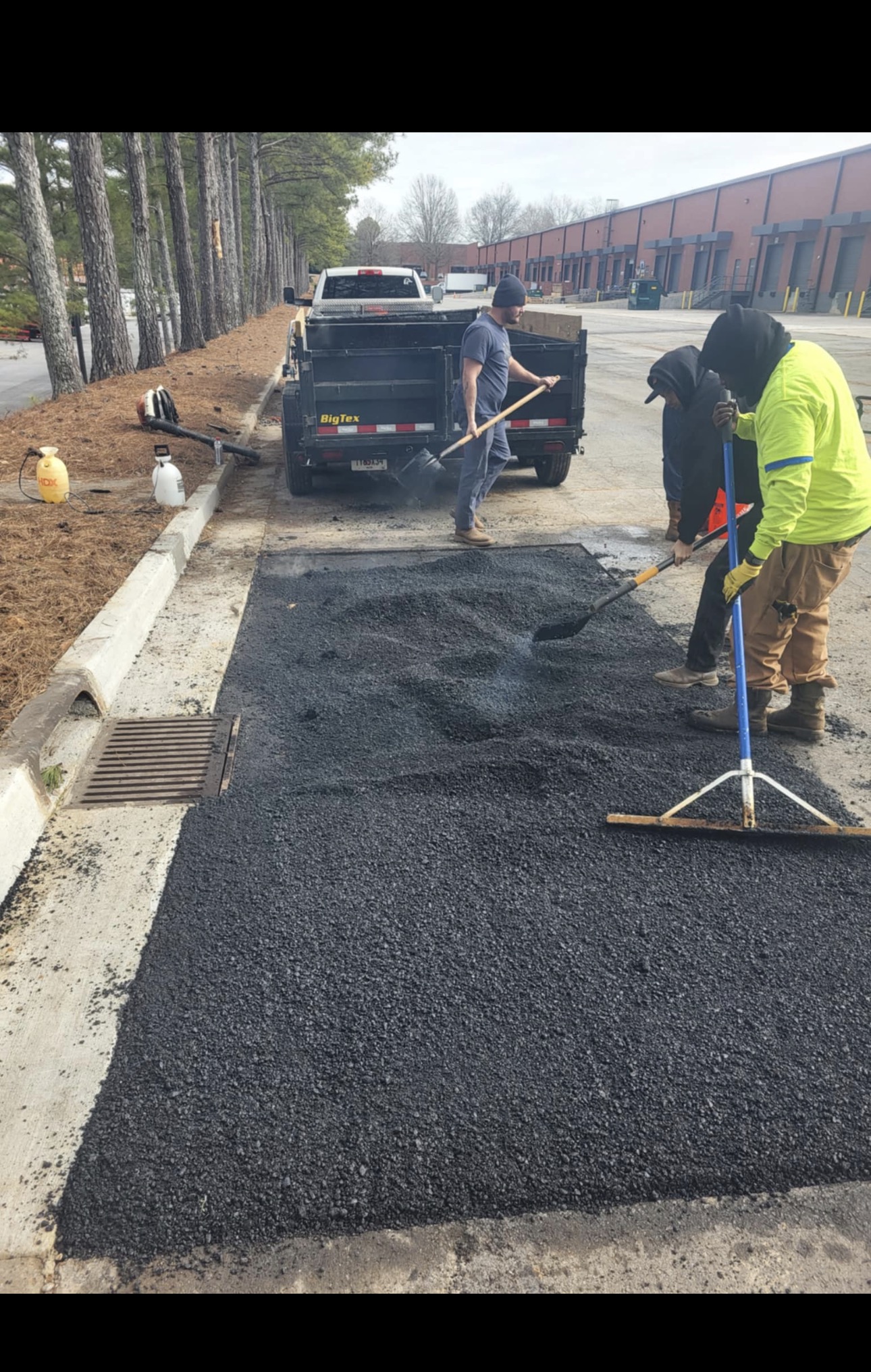 CCL crew raking fresh asphalt during a driveway repair