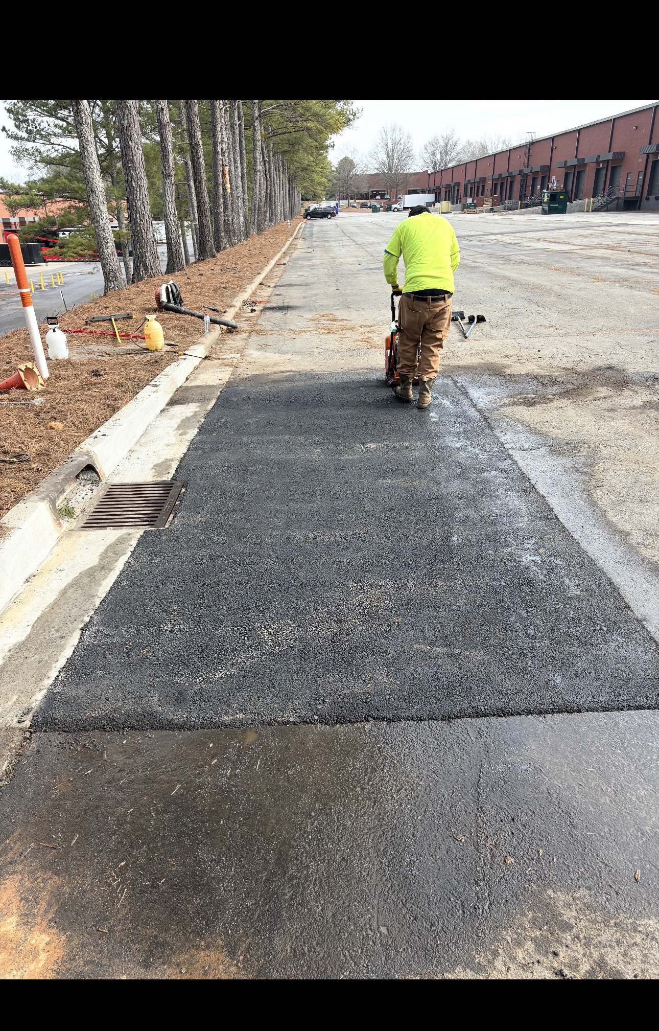 CCL crew finishing a fresh asphalt paving job on a parking lot drive