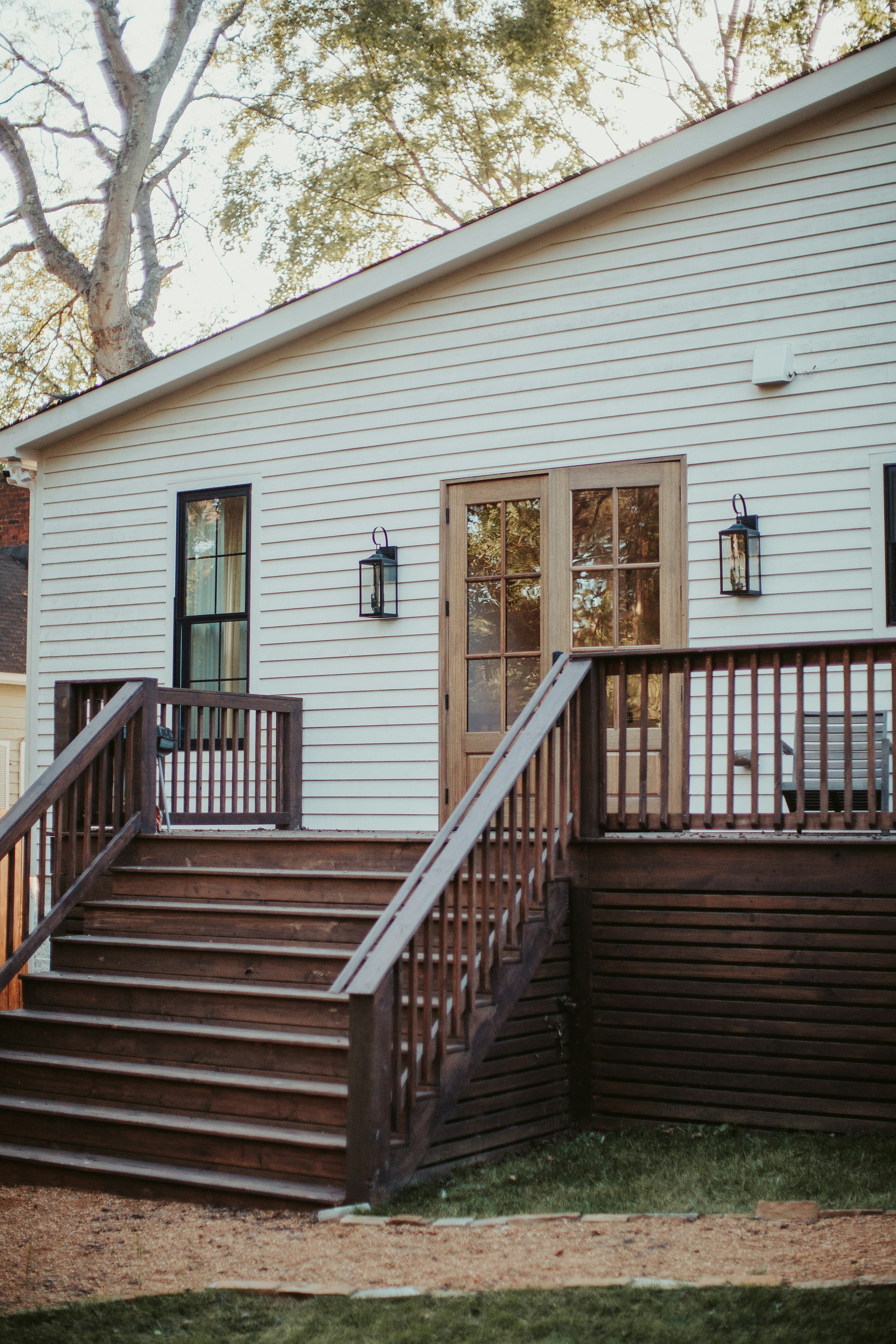 White Southern home with freshly stained wood deck and stairs